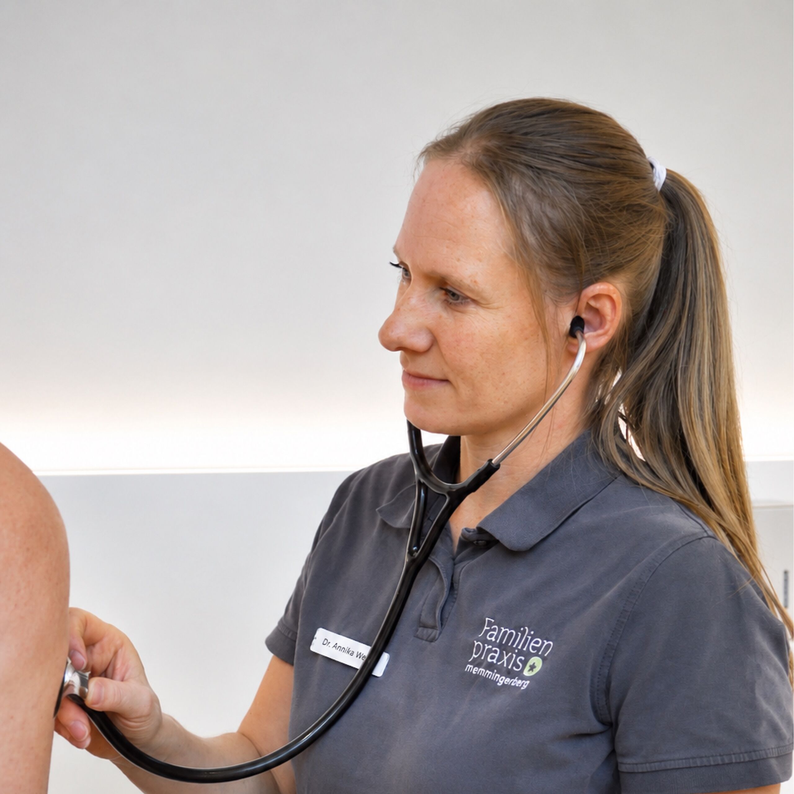 Ärztin hört mit Stethoskop die Lunge eines Patienten ab